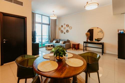 迪拜Cozy 1 Bedroom in the heart of Dubai Marina的客厅配有木桌和椅子