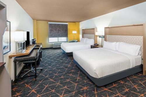 塔尔萨塔尔萨南假日套房酒店的酒店客房配有两张床和一张书桌