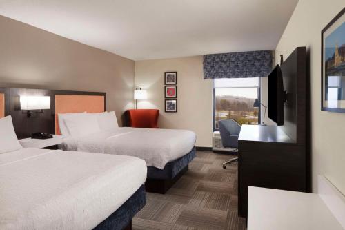 查尔斯顿Hampton Inn Charleston-Southridge的酒店客房设有两张床和电视。