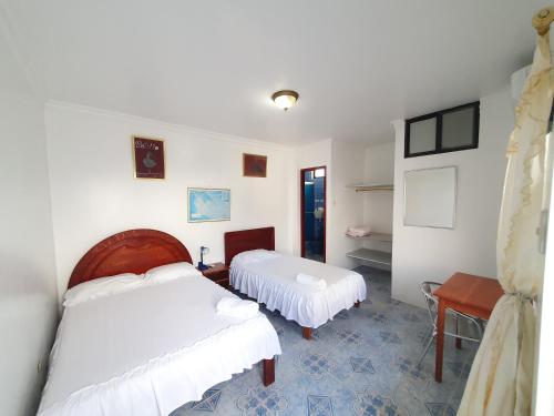 比亚米尔港Hostal Insular的一间卧室配有两张床和一张桌子