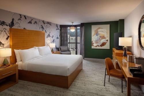 里诺Whitney Peak Hotel Reno, Tapestry Collection by Hilton的酒店客房配有一张床、一张桌子和一把椅子。
