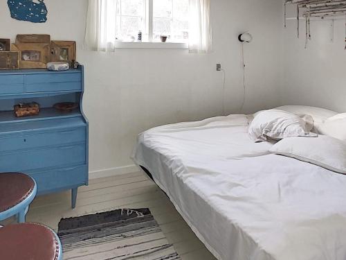 维斯特索马肯Holiday home Aakirkeby VIII的一间卧室配有蓝色梳妆台和一张床