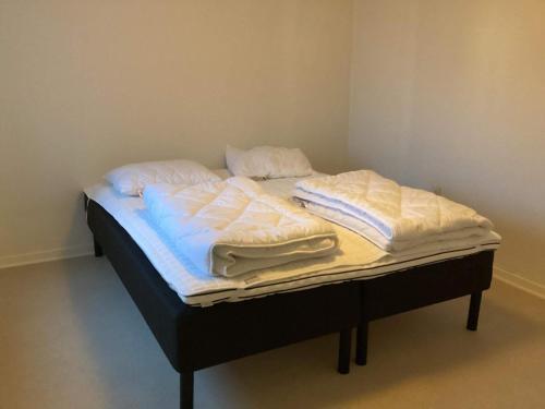 北内伯尔Holiday home Nørre Nebel III的一张带白色床单和枕头的床