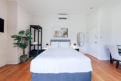悉尼Gaslight Inn - Adults Only的卧室配有一张白色的大床和一张桌子