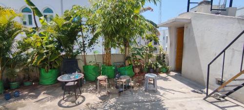 钦奈Hostel Gandhi的庭院配有桌椅和植物