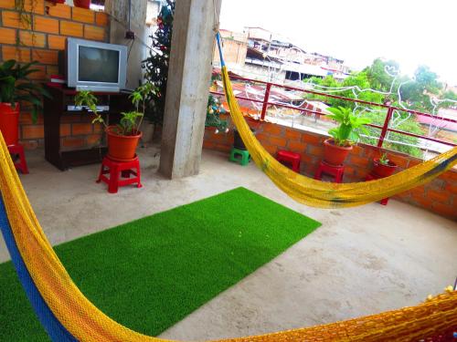 塔拉波托Hostel Flor del Valle的阳台的吊床,配有电视和植物