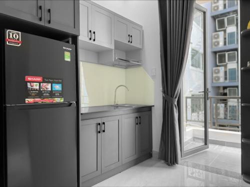 胡志明市Newhome luxury apartment的厨房配有白色橱柜、水槽和窗户。