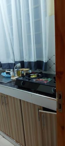 RuiruAirbnb的厨房柜台配有炉灶和餐具。
