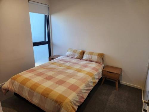 墨尔本Modern Apartment Airport Area的一间卧室配有一张带拼接棉被的床