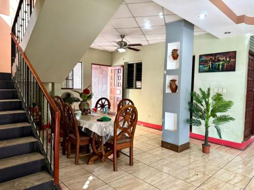 马那瓜Villalobos Hotel Managua的一间带桌椅和楼梯的用餐室