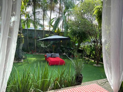 弗洛里亚诺波利斯UFSC Guest House的一个带桌子和遮阳伞的花园