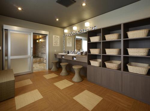 成田若松本酒店的浴室配有水槽和带篮子的梳妆台。