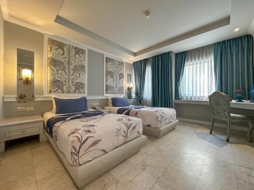 清迈平纳坤酒店的酒店客房配有两张床、一张书桌和一张书桌。
