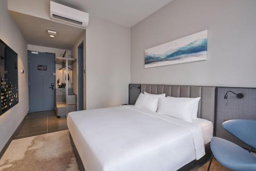 吉隆坡莱恩酒店的卧室配有白色的床和蓝色椅子