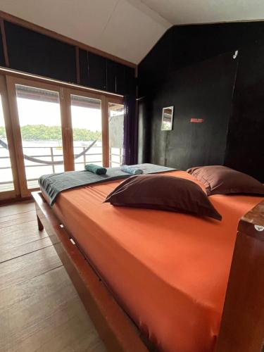 沙璜Olala Bungalows and Restaurant的一张大橙色床,位于一个窗户的房间