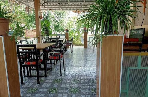 木州县Lưng Đồi Homestay Mộc Châu的一间设有桌椅和盆栽的餐厅