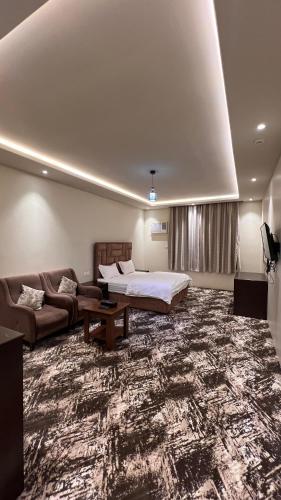 Al ḨawīyahRadiha Hotel Suites的客厅配有床和沙发