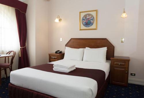 肯图巴皇宫酒店的酒店客房带一张大床,带白色床单
