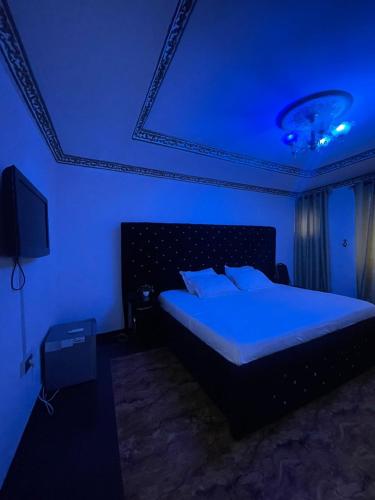 拉各斯Ikorodu Guest House的蓝色客房中一间带床的卧室