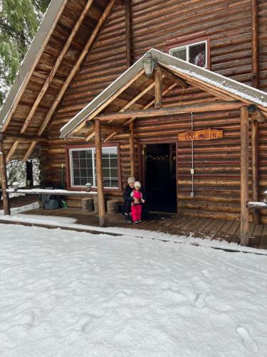 阿什福德Log Cabin at Rainier Lodge (0.4 miles from entrance)的两个孩子站在小木屋门口