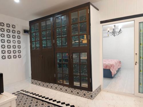 春蓬At Night的客房设有带玻璃门的大型木制橱柜。