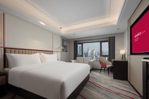 南京南京滨江雅高瑞享酒店的酒店客房带白色的床和投影屏幕