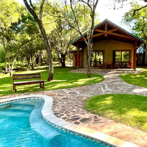 SimunyeMbuluzi Game Reserve的一个带长凳和游泳池的房子