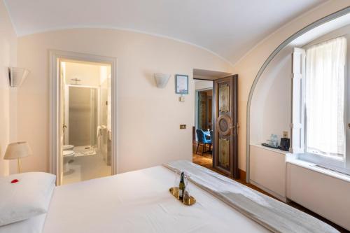 罗马玛蒂娜别墅的白色的客房配有一张带镜子的床