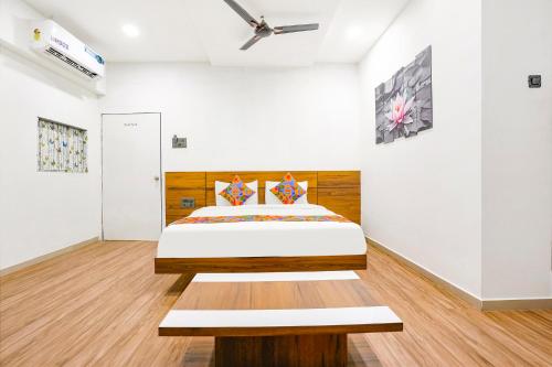 苏拉特FabHotel 7 Star的一间卧室配有一张带木制床头板的床