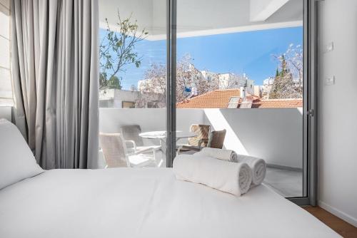 特拉维夫KG4 LUX Apartments的卧室设有白色的床和大窗户