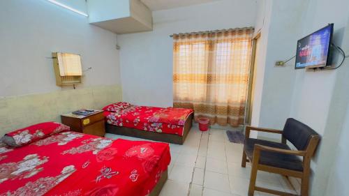 达卡Hotel Al Makka的一间卧室设有两张床、一台电视和一把椅子