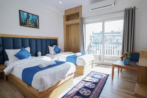 瑞诗凯诗Tripli Hotels Ayushman Retreat的酒店客房设有两张床和大窗户。