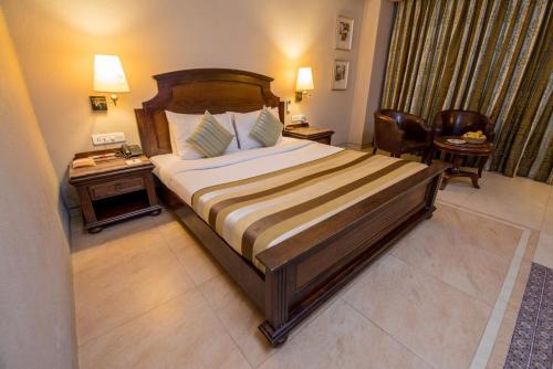 巴雷利Hotel Le Cypress的酒店客房设有一张大床和一张桌子。