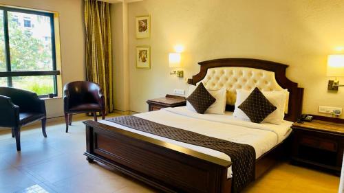 巴雷利Hotel Le Cypress的一间卧室设有一张大床和一个窗户。