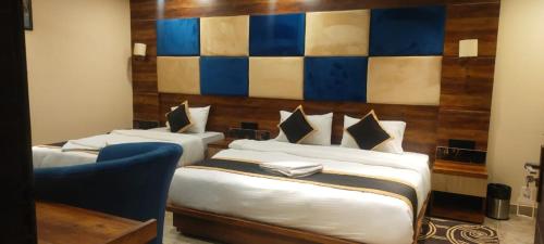 Koch BihārPoddar Residency的一间卧室配有两张床和一张蓝色椅子