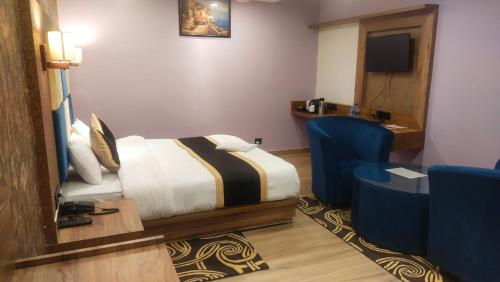 Koch BihārPoddar Residency的酒店客房配有一张床、一张桌子和一把椅子。