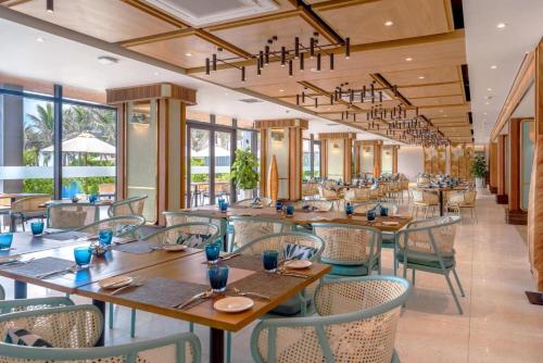 金兰Big Star Villas - Wyndham Garden的餐厅设有木桌、椅子和窗户。