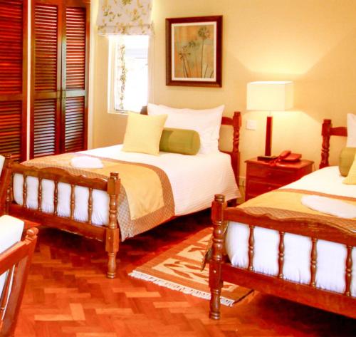 Mweiga阿伯德尔乡村俱乐部酒店的一间卧室设有两张床和窗户。