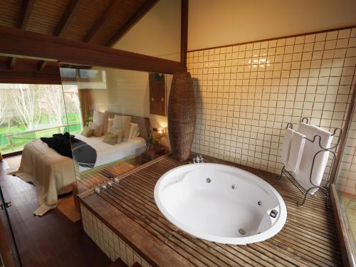 Lugás卢卡斯庭院旅馆的带浴缸的浴室和卧室