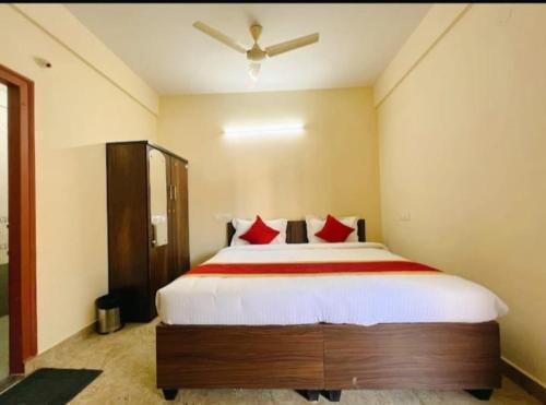 班加罗尔Sai Manyata Inn, Bangalore的一间卧室配有一张带红色枕头的大床