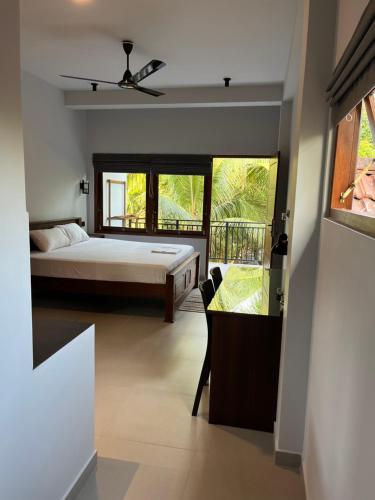 米迪加马东Cozy Corner - Midigama的一间卧室设有一张床,享有阳台的景色