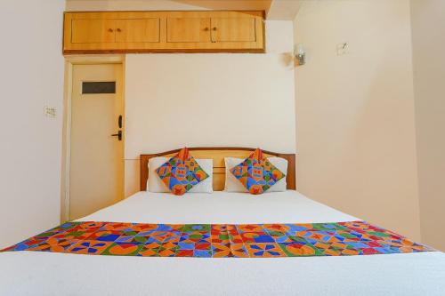 乌提FabHotel MM Abode的一张带五颜六色的被子和两个枕头的床