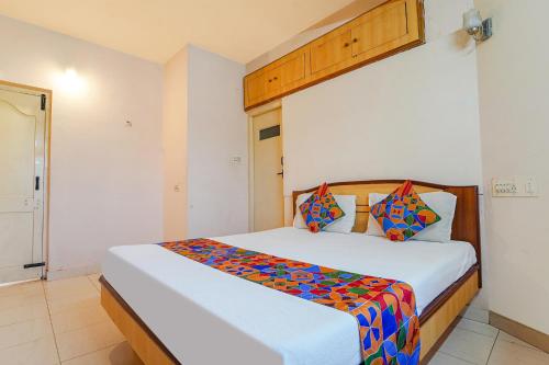 乌提FabHotel MM Abode的卧室配有一张大白色床和色彩缤纷的床单