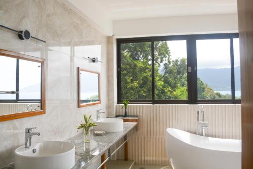 GlacisSunbird Villas的一间带两个盥洗盆的浴室和大窗户