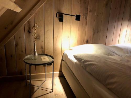 斯哈伦代克Grevelingenhuys的一间卧室配有一张床和一张带台灯的桌子