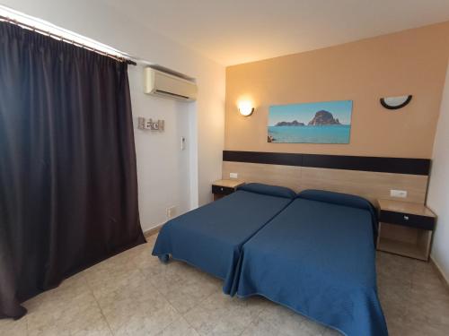 圣安东尼奥霍利松特旅馆的一间卧室配有一张带蓝色毯子的床