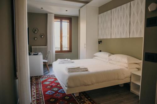 维罗纳Naboo Verona Luxury Suites的卧室配有一张白色大床和红色地毯