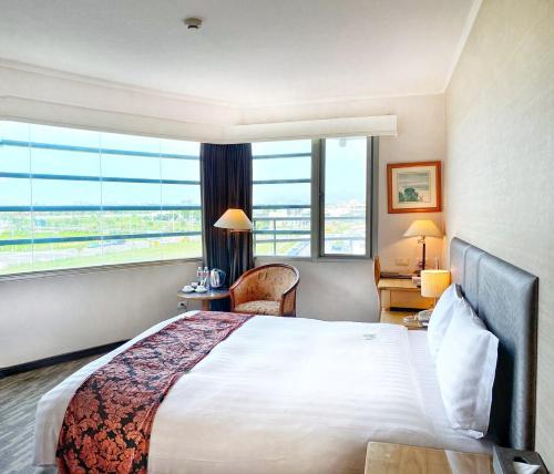 台中市Golden Tulip Zhong Xin Hotel Taichung的酒店客房设有一张床和一个大窗户