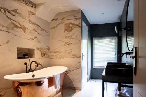 海尔伦Van der Valk Hotel Kasteel Terworm的带浴缸和盥洗盆的浴室