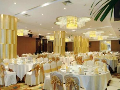 苏坡桥Chengdu Yinsheng International Hotel的一个带白色桌椅的大型宴会厅